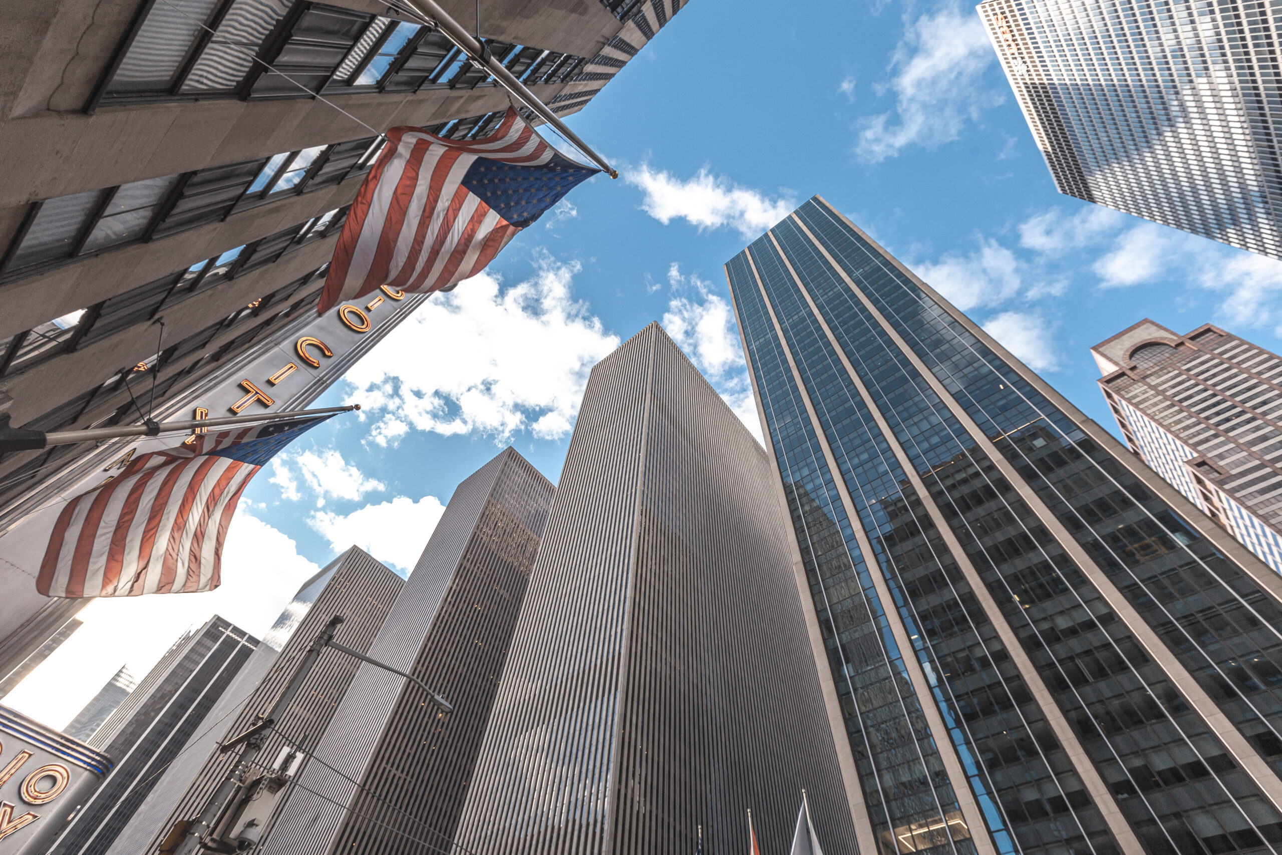 New York, United States »; January 5, 2020: Skyscrapers in Manhattan with American flags and sky above